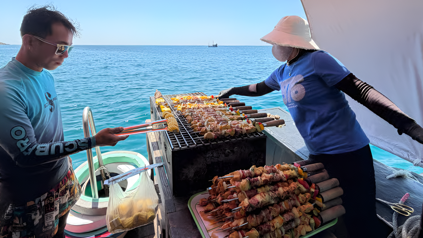 Grilling BBQ skewers and corn on the boat deck