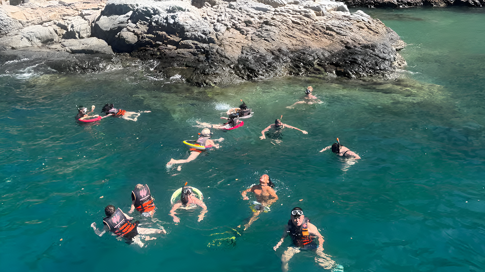 Group snorkeling near a rocky cove in Nha Trang Bay